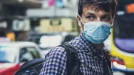 man on a busy street wearing a face mask